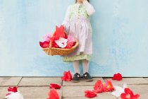 Fille tenant panier de fleurs en papier — Photo de stock
