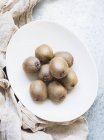 Plate of whole kiwi fruits — Stock Photo