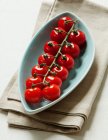 Tomates cereja em prato de serviço azul — Fotografia de Stock