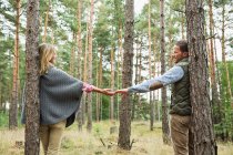 Mid casal adulto de mãos dadas na floresta — Fotografia de Stock