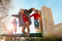 Crianças pulando de alegria no parque, foco em primeiro plano — Fotografia de Stock