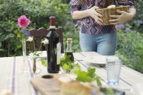 Cropped image of woman setting table in green garden — Stock Photo