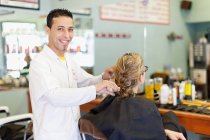 Barbier travaillant sur le client dans la boutique — Photo de stock