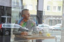 Зрелый мужчина, сидящий в кафе — стоковое фото