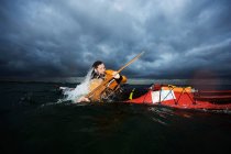 Hombre en kayak rotando en el mar - foto de stock