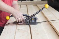 Close up of male warehouse worker fastening wooden planks in hardware store — Stock Photo
