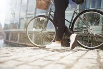 Frau schiebt Fahrrad am Kanal entlang — Stockfoto