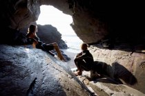 Пара сидить на великих каменях у гідрокостюмі — стокове фото