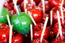 Груда красных и зеленых конфетных яблок, крупным планом — стоковое фото