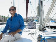 Зрілий чоловік в сонцезахисних окулярах на яхті — стокове фото