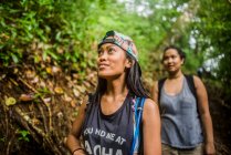Дві молоді жінки - туристки гуляли джунглями в Маноа - Фоллс (штат Оаху, Гаваї, США). — стокове фото