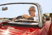 Uomo anziano guida in auto sportive — Foto stock