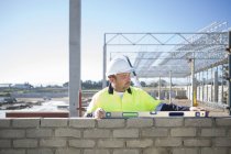 Builder using spirit level on construction site wall — Stock Photo