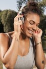 Молода жінка насолоджується музикою на своїх навушниках — стокове фото