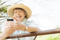 Mujer mayor sonriendo en el mensaje en el teléfono móvil - foto de stock