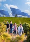 People walking by solar panels — Stock Photo