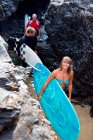 Tre persone che trasportano tavole da surf — Foto stock