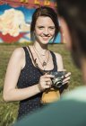 Young couple taking photographs on SLR camera at funfair — Stock Photo