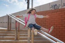 Mädchen rutscht Treppengeländer hinunter — Stockfoto