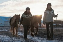 Donne che camminano con i cavalli all'aperto — Foto stock