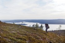 Caminhante cruzando campo por lago, Keimiotunturi, Lapônia, Finlândia — Fotografia de Stock