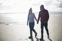 Молодая пара, гуляющая по пляжу, Брин Сэндс, Сомерсет, Англия — стоковое фото