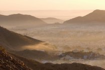 Fog rolling over mountain towns — Stock Photo