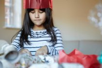 Girl wrapping presents at desk — Stock Photo