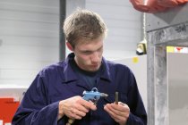 Männlicher Ingenieur, der Ausrüstung in Fabrik repariert — Stockfoto
