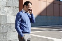 Зрілий бізнесмен використовує мобільний телефон на відкритому повітрі — стокове фото