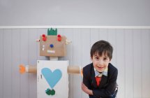 Junge steht neben selbstgebautem Roboter — Stockfoto