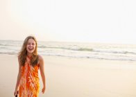 Усміхнена дівчина гуляє на пляжі — стокове фото