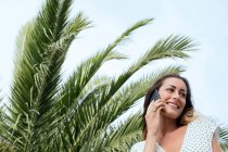 Молода жінка розмовляє на смартфоні на відкритому повітрі — стокове фото
