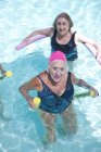 Portrait of senior women doing exercise in swimming pool — Stock Photo