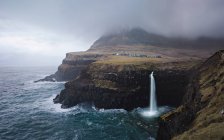 Wasserfall an felsiger Küste — Stockfoto