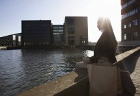 Businesswoman taking break by waterfront, Copenhague, Dinamarca - foto de stock