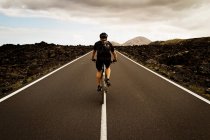 Ciclismo hombre en medio de la carretera al aire libre - foto de stock