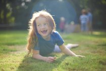 Junges Mädchen liegt auf Gras im Garten — Stockfoto