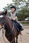 Хлопчик верхи на коні у дворі, вибірковий фокус — стокове фото