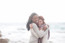 Amigos abrazándose en la playa - foto de stock