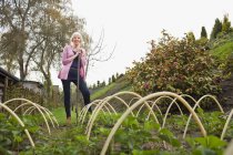 Зрелая женщина, стоящая в огороде — стоковое фото