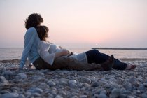 Jeune couple allongé sur la plage — Photo de stock