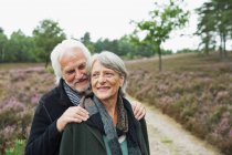 Senior couple, man with hands on woman's shoulders — Stock Photo