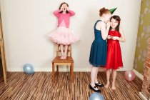 Tres chicas jugando a las escondidas en la fiesta de cumpleaños - foto de stock