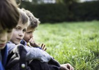 Три мальчика, сидя вместе в поле, осенью — стоковое фото