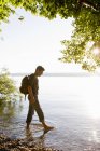 Зрілий чоловік веслує в озері на заході сонця — стокове фото