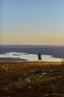 Человек отдыхает после бега по вершине скалы на закате, Омиотунтури, Окланд, Финляндия — стоковое фото