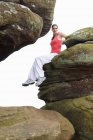 Woman sitting on rock formations — Stock Photo