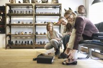 Familia femenina de tres generaciones probando zapatos en zapatería - foto de stock
