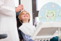 Хлопчик у стоматологічному кріслі, оглянувшись — стокове фото